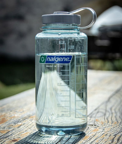 A clear water bottle sits on a wooden table.