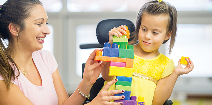 handicapped girl plays with building blocks