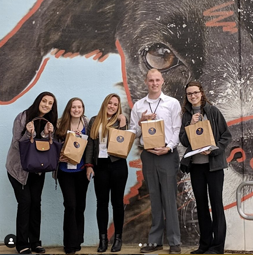 PRSSA students hold up gift bags outside of conference at WVU.