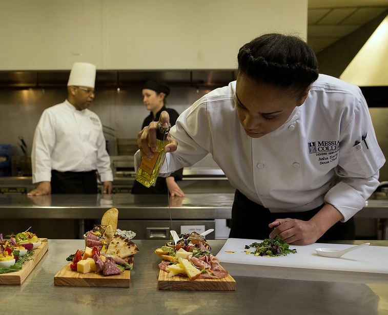 Chef applying oil to food