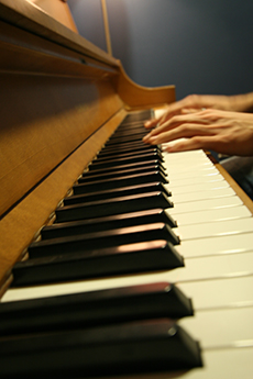 Hands resting on piano keys.