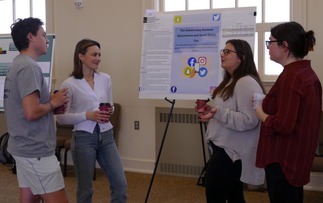students discussing research poster