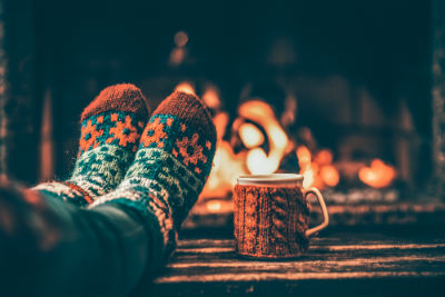 Christmas socks and a mug in front of a wood fire