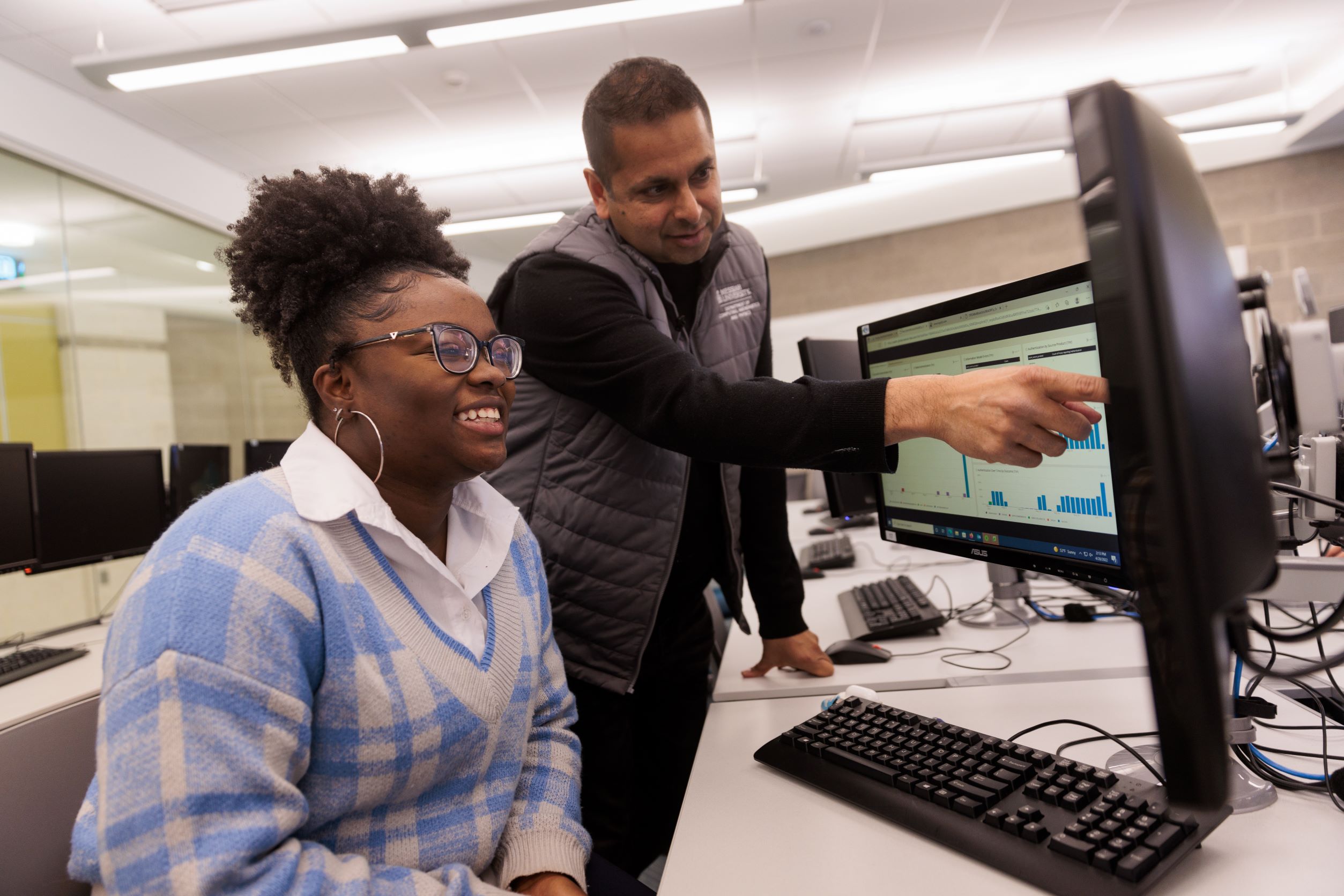 Professor Sakore teaching student in a lab.