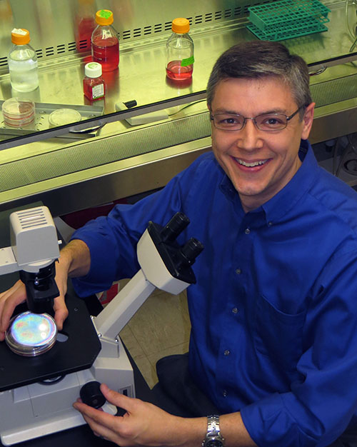 Portrait of John Harms with his microscope 