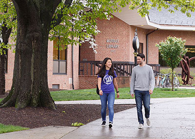 Two students walking in front of the library