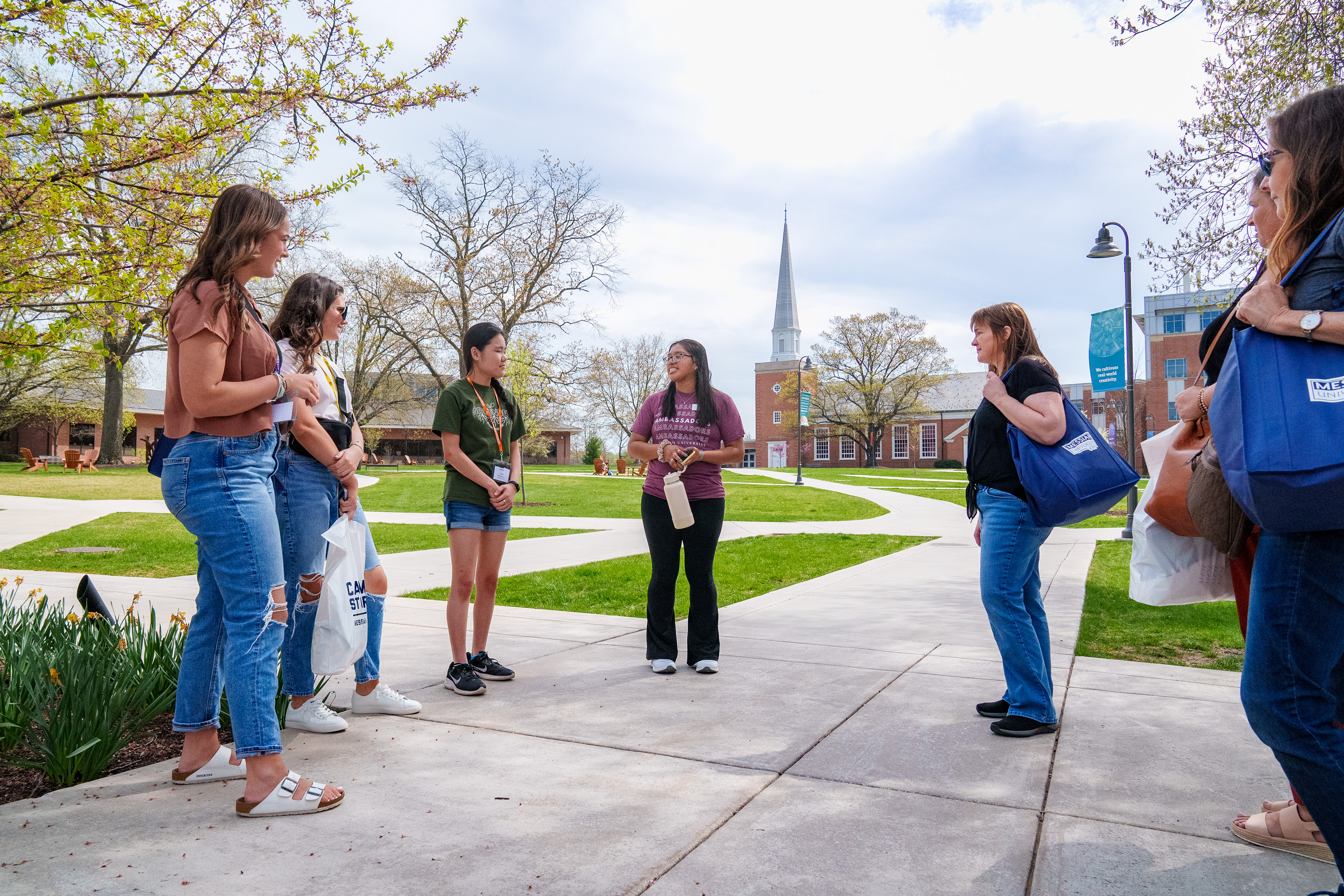 families talking with a tour guide with chapel spire in the background