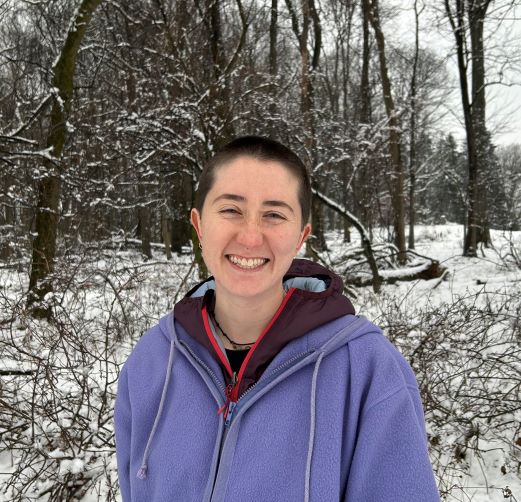 headshot of Ally Austen outside with snowy woods behind her
