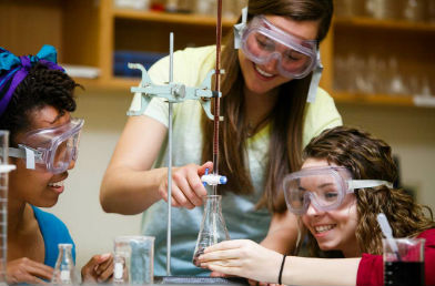 Students measuring liquids in beakers