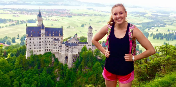 Student backpacking above German castle