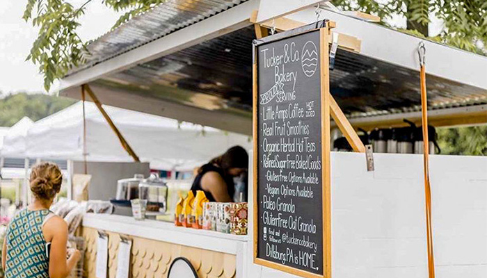 A coffee truck sits outside as a woman orders.