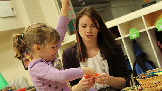 A student instructing a baby.