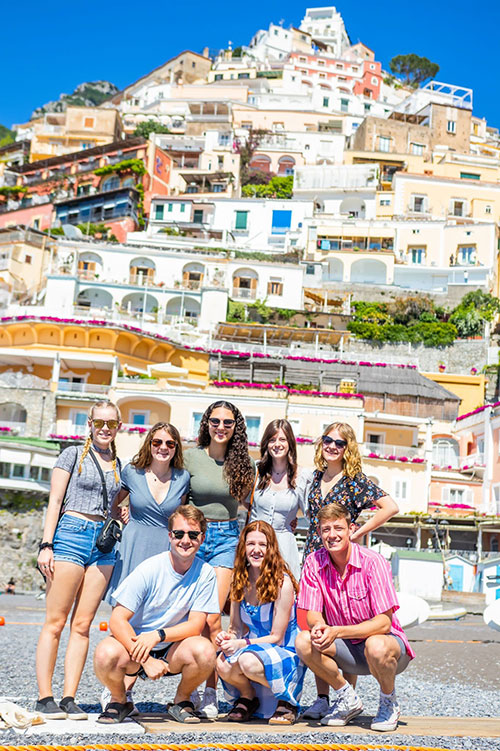 Students in Italy with beautiful background of colorful houses and blue sky