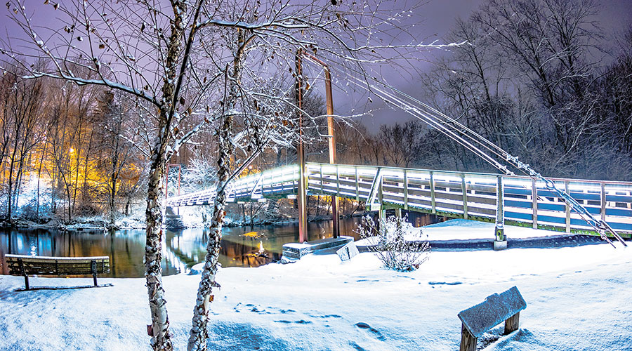 Photo of metal bridge in snow with subtle lighting