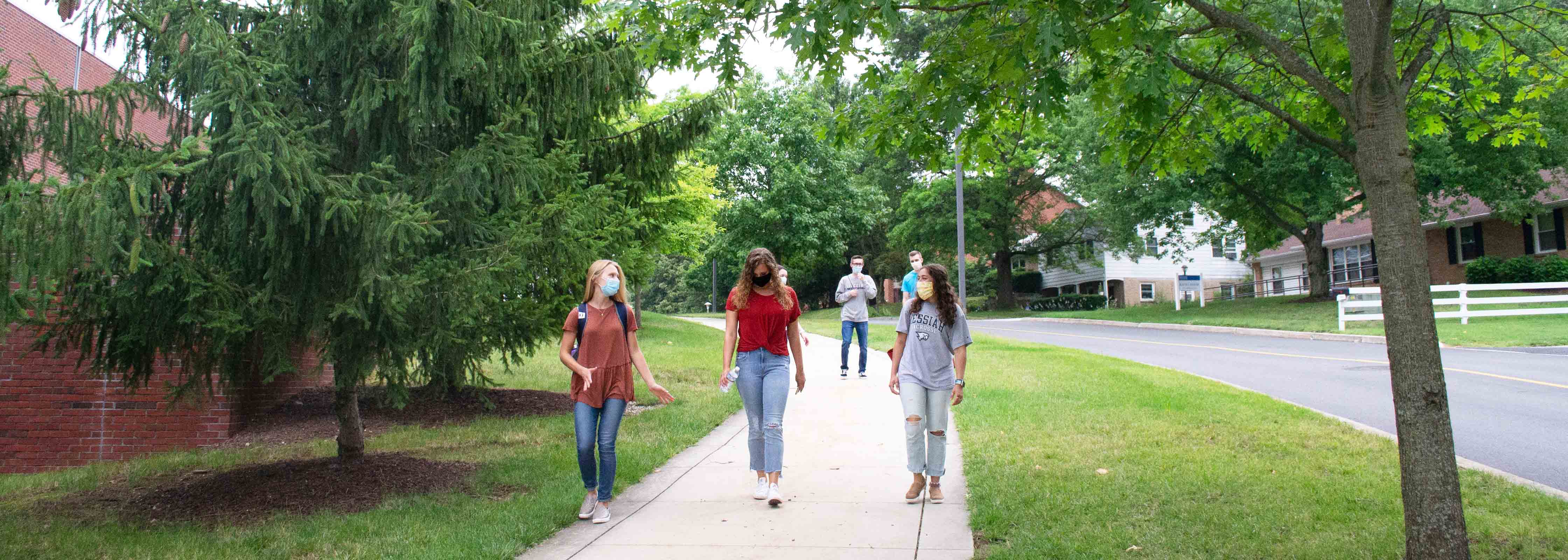 Group of students wearing mask walking near Larsen Student Union