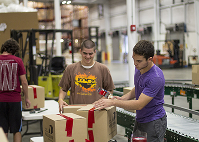 Students packing cardboard boxes.