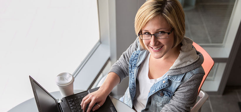 Smiling student using laptop