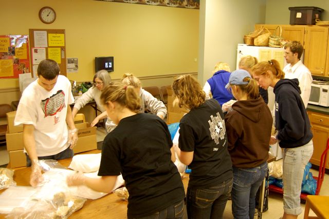 Student employees around a table, wrapping items.