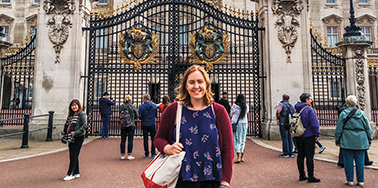 Woman Stands in front of iron gate