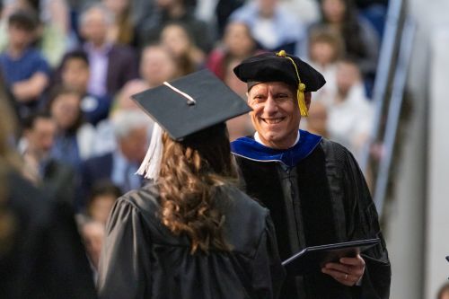Jon giving away a diploma at commencement. 