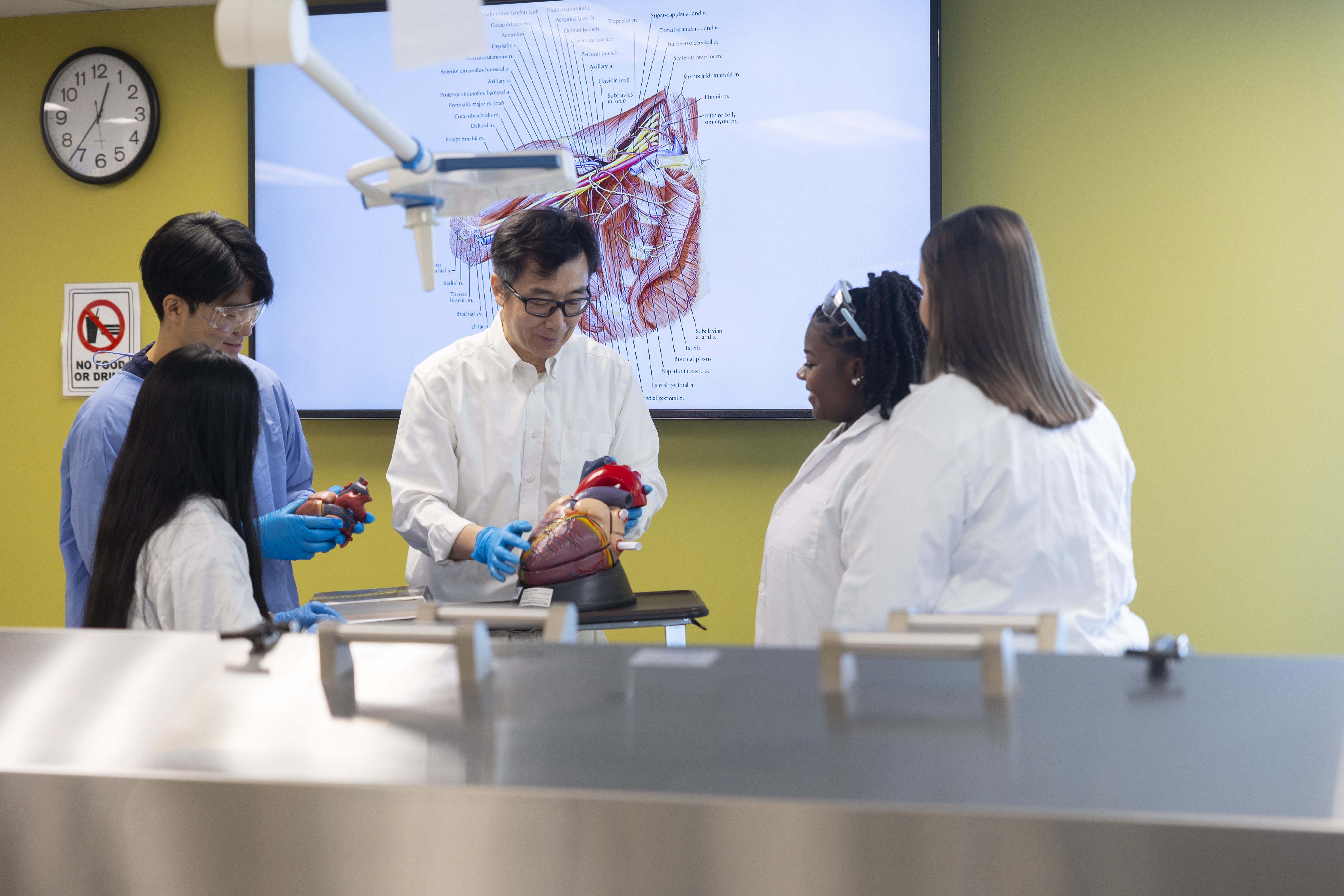 Small group of students standing with faculty member in science lab