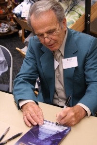 President Hostetter autographs copies of his memoir