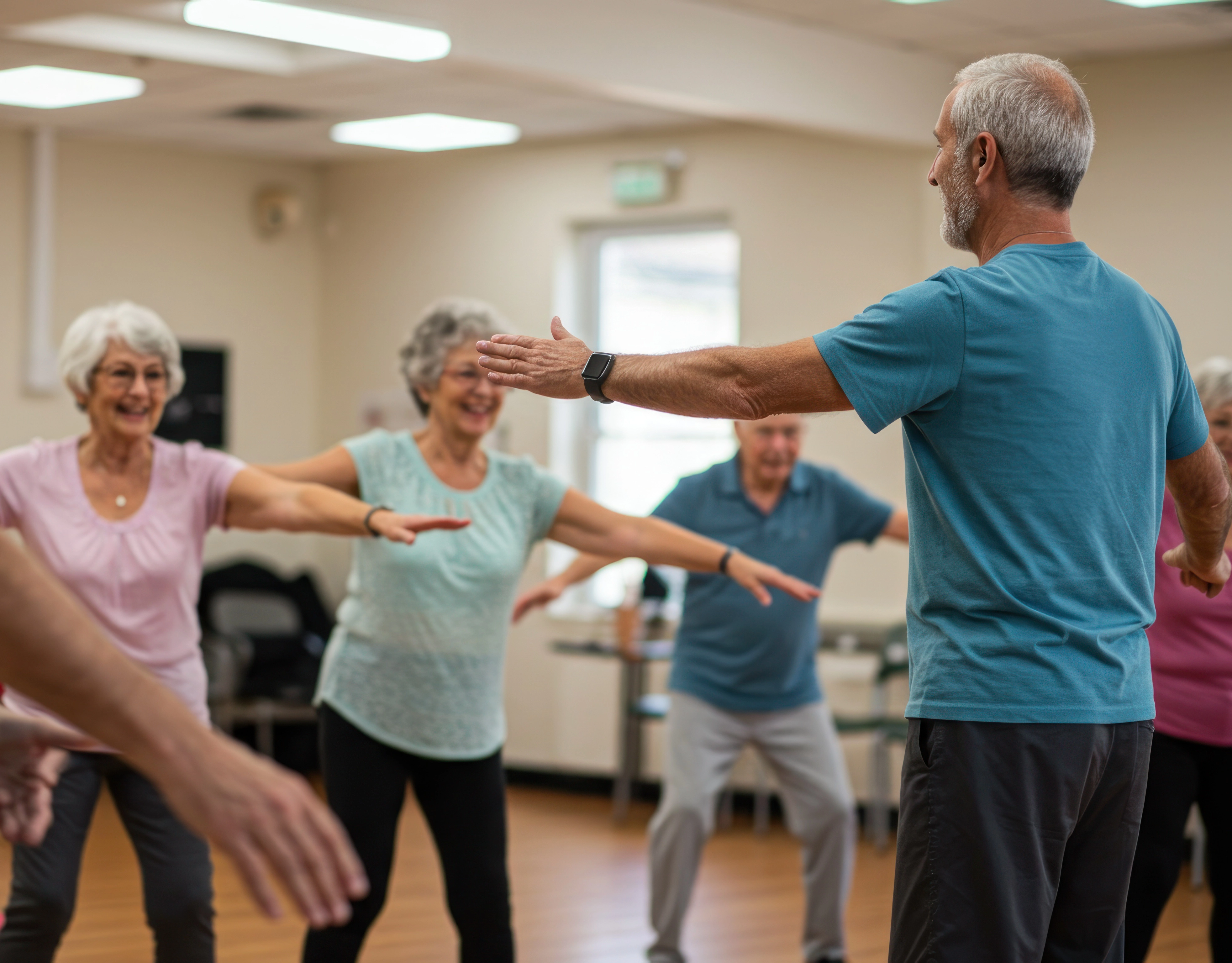 an older gentleman leads older women in a dance class