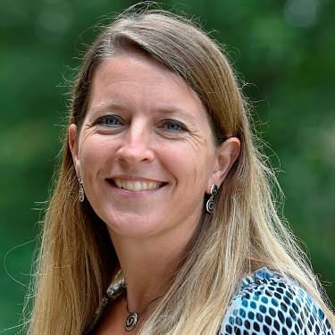 A woman with long hair smiles for the camera.
