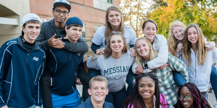 A group of students smiles together for a photo.