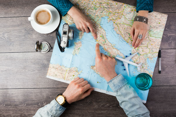 Two people point at map