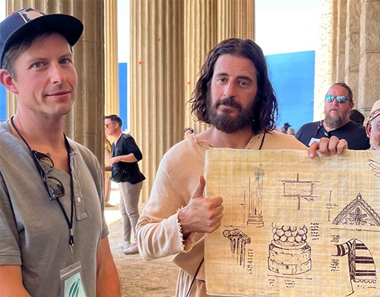 Stephen Procopio standing with Jesus from The Chosen, who is holding Stephen's artwork.