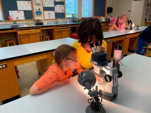 Girl and Boy using a microscope.