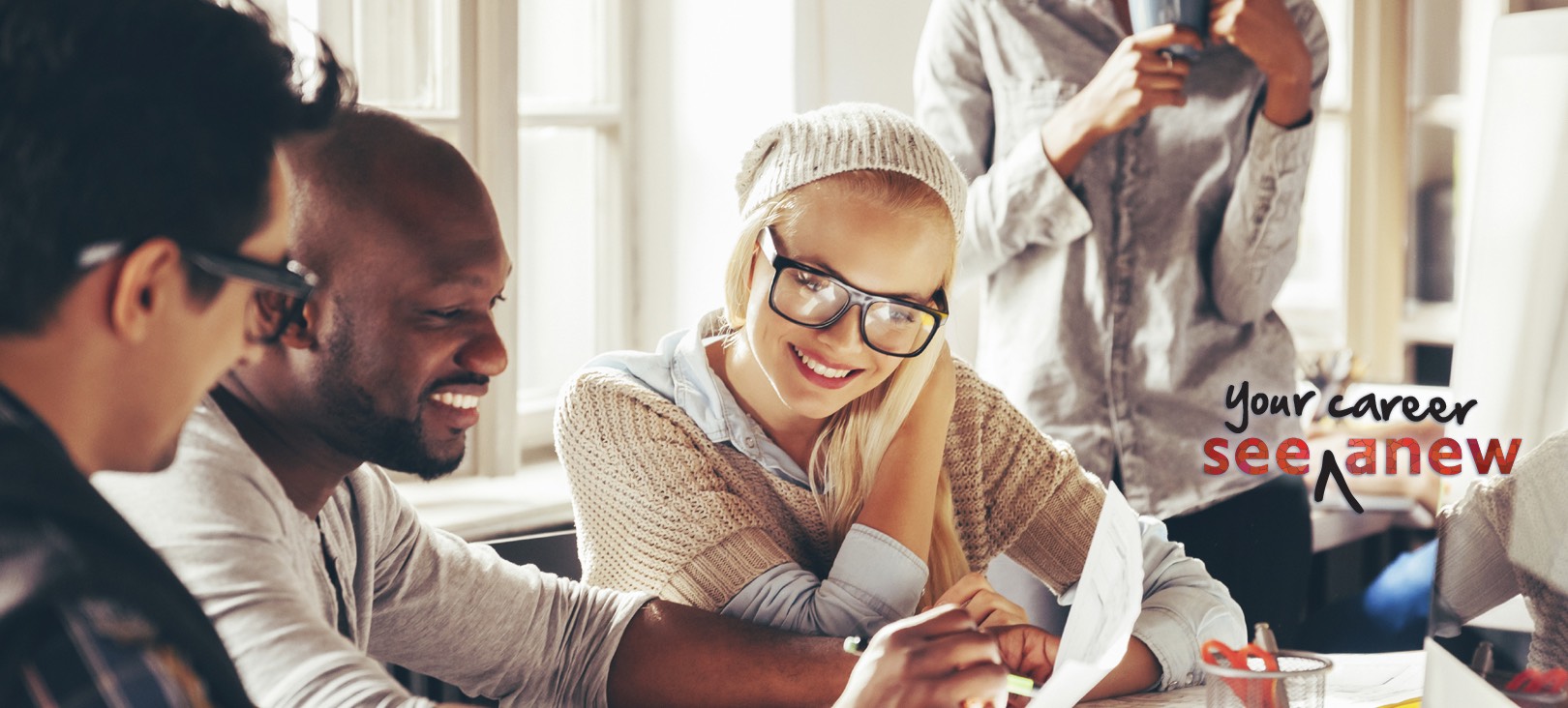 Graduate Degree: Business and Leadership (MBA, M.A.) A woman wearing beanie and glasses sitting next to an african american man looking at a paper.jpg