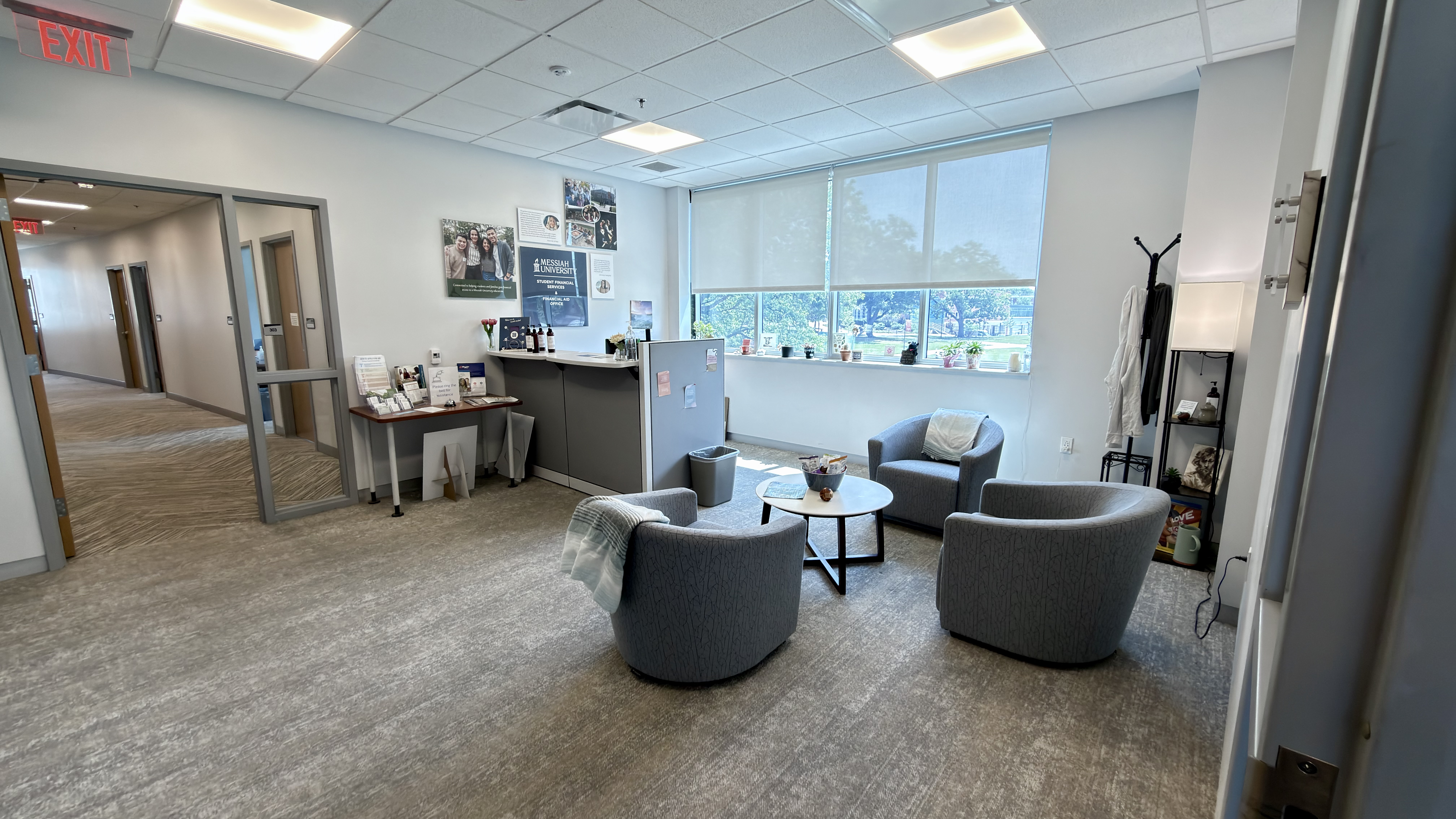lobby of sfs with 3 gray chairs, gray carpet, and welcome desk