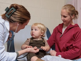 Mother with young child in doctors office with a nurse