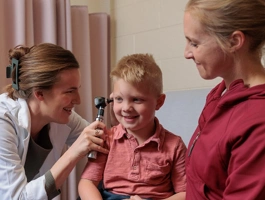 Nurse working with a mother and small child in a clinic setting