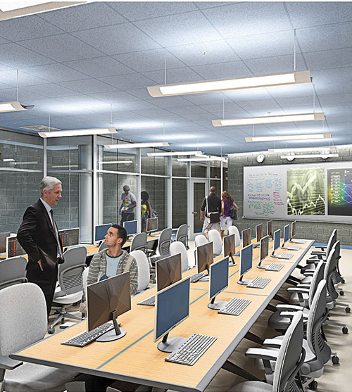 Modern classroom with computers and collaborative seating, featuring a teacher discussing with a student.