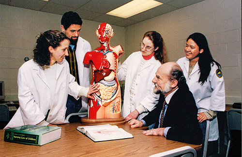 Nursing students in 1998 gather around an anatomy dummy