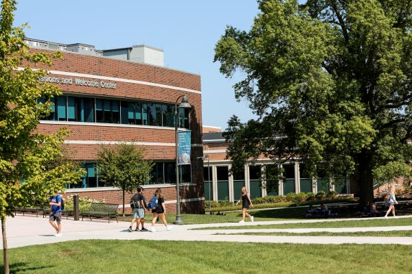 students walking on sidewalks in front of the Phipps Welcome Center