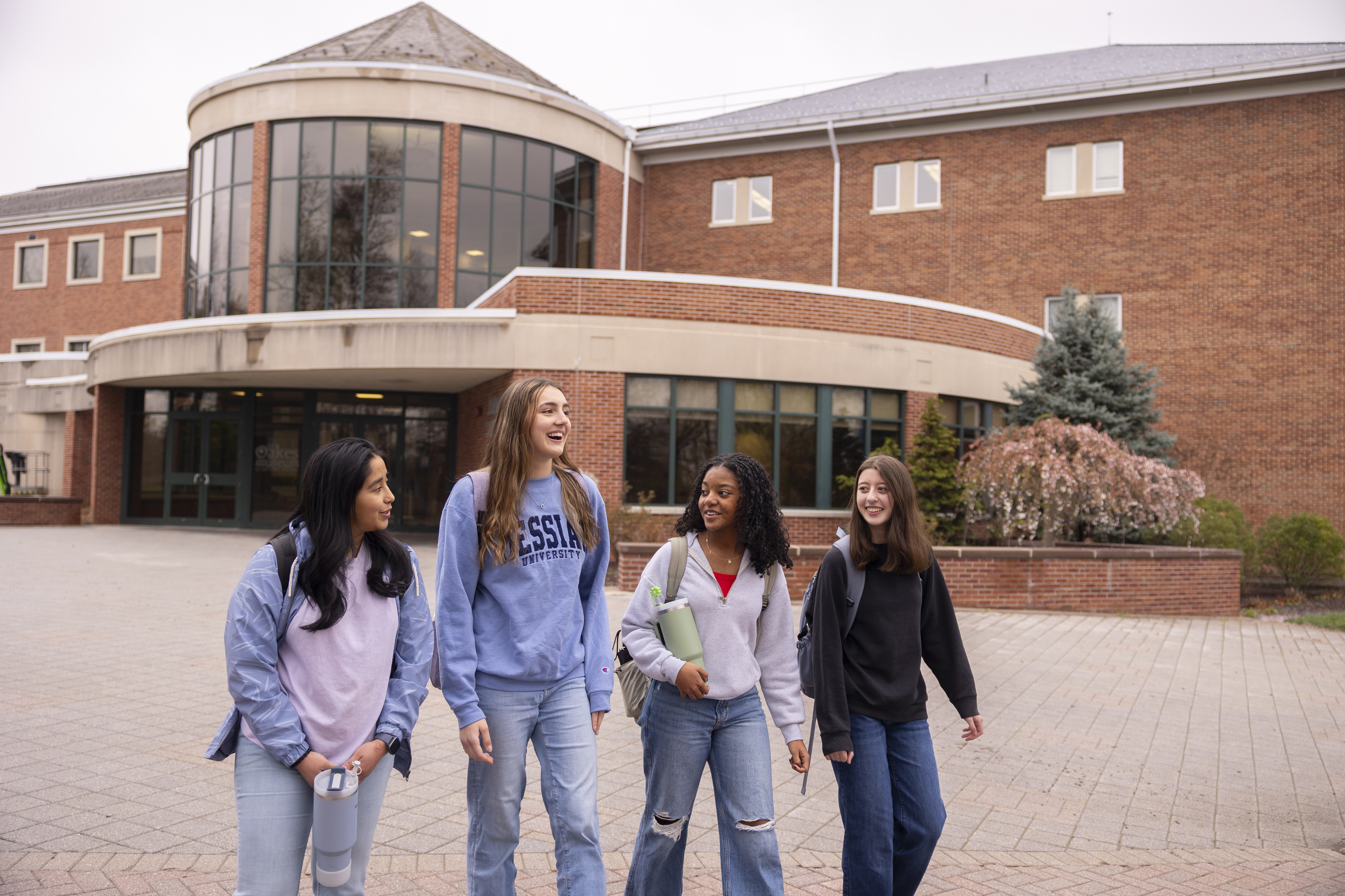 Four students walking in front of Jordan Kline