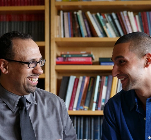 Professor and student talking in library