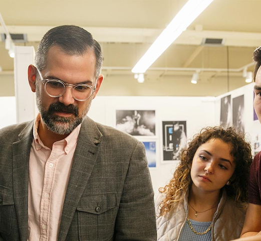 Professor and student discussing art piece
