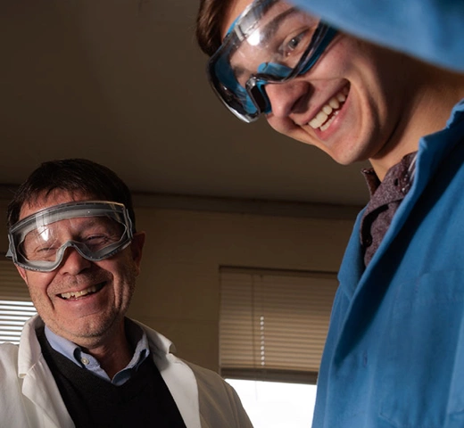 Professor with safety glasses on working in chemistry lab