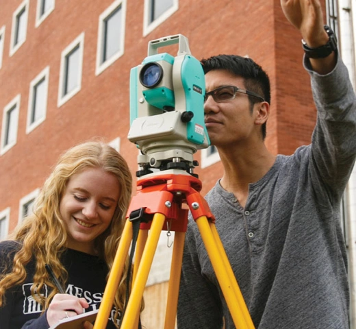 Male and female engineering student looking through survey tool