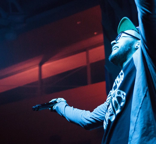 Student performing on stage with dramatic lighting