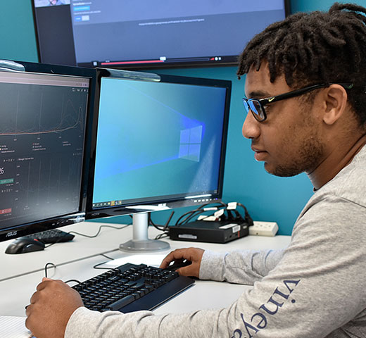 student working at a computer doing cybersecurity