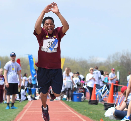 students helping a disabled youth in jumping