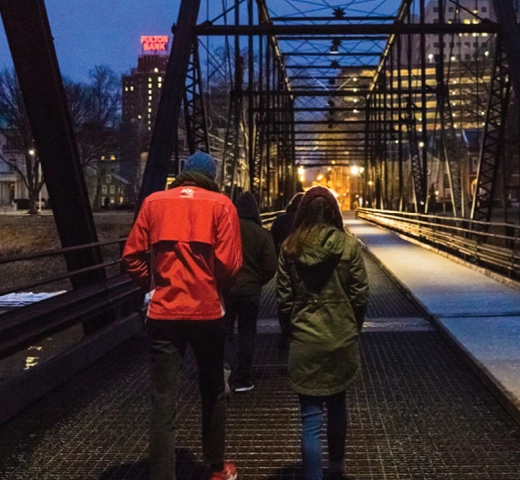 students walking a bridge in a city