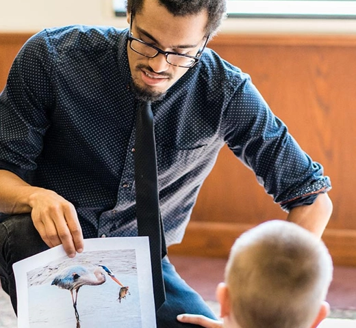 student reading to youth in a classroom