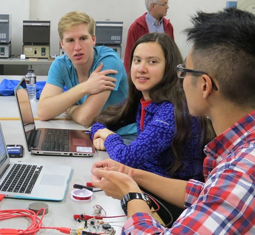 students at a table working together on electrical studies